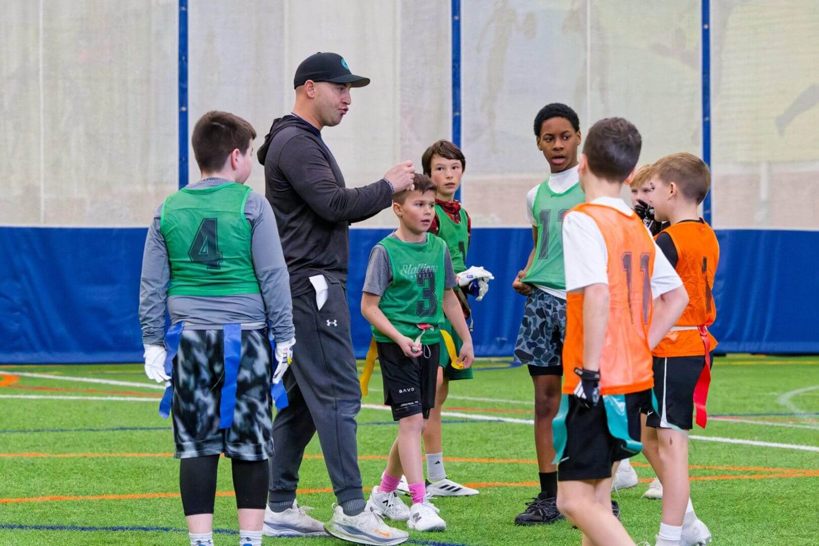 Coach instructing youth flag football team
